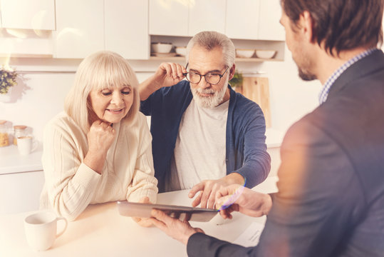 Positive aged couple meeting with a real estate agent - Powered by Adobe