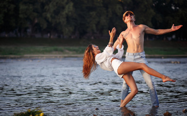 young lovers sexy couple dancing in the water in the river