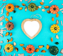 Decorative pumpkins on trendy blue background with fall leaves.