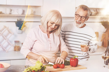 Cheerful aged couple cooking in the kitchen