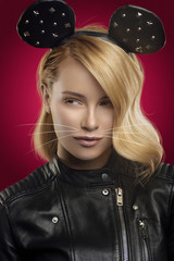 Fashion studio portrait of pretty blond in black jacket with mouse ears and makeup