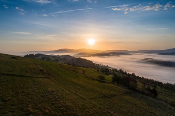 Naklejka na ściany i meble Beautiful foggy sunset in Polish mountains Silesian Beskid.