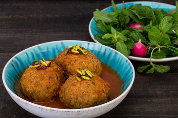 Koofteh Tabrizi Large Meatballs Stuffed With Dried Fruits And Nuts In Tomato Turmeric Broth A Traditional Azeri And Iranian Dish Served In Turquoise Bowl Garnished With Pistachio and Barberries