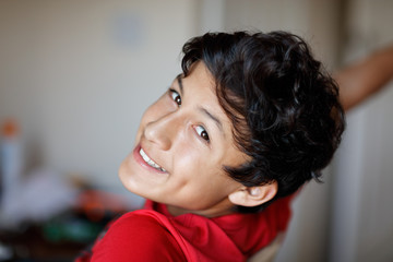 A young teenage boy smiles during his homework - shallow depth of field