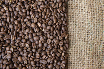 coffee beans background on sack cloth.Texture with copy space of roasted coffee beans on gunny bag
