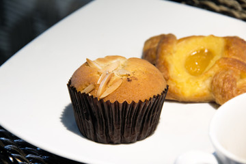 banana cup cake and croissant on white plate.