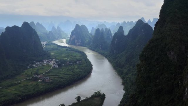 Beautiful Chinese natural landscape with karst hills, mountains, town and countryside between Yangshuo and Guilin, China, Asia. Tourist cruise ships on Li River, seen from Xianggong Hill viewpoint