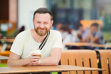 young man with a drink outdoors in the city