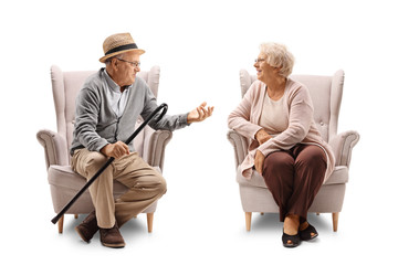 Elderly man and elderly woman in armchairs talking