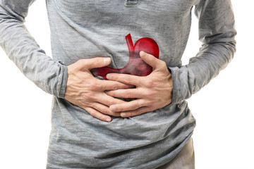 Man suffering from abdominal pain on white background, closeup