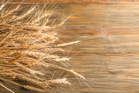 Ripe spikelets on wooden background
