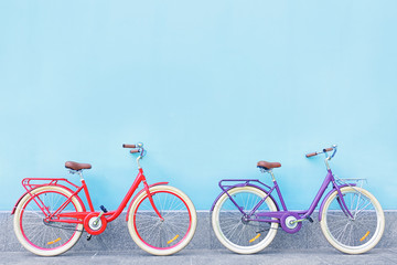 Stylish new bicycles near color wall outdoors