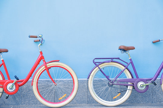 Stylish new bicycles near color wall outdoors
