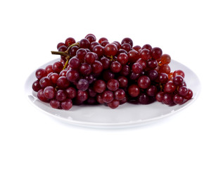 Red grape bunch in white plate isolated on white background