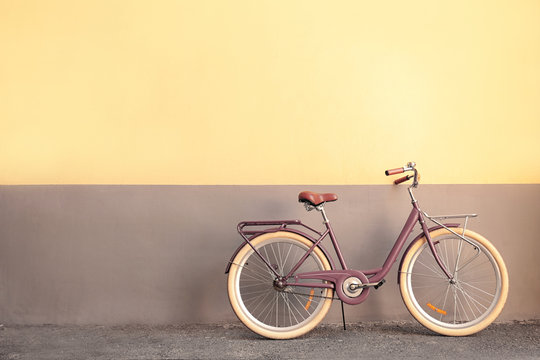 Fototapeta Stylish new bicycle near color wall outdoors