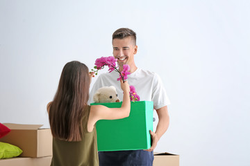 Young happy couple with cardboard box in room