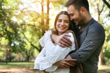 Young happy couple standing in park embracing. Couple in nature. © liderina