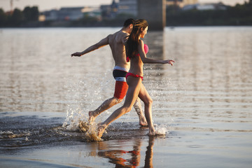 Happy couple running in water