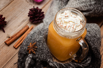 Fresh pumpkin lattem smothie  with whipped cream on wooden rustic background, selective focus