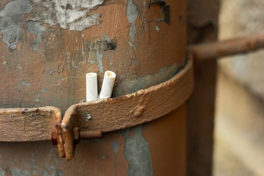 Cigarette cigarette butts in a drainpipe, pollution of the city