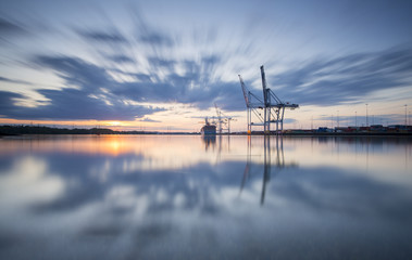 Southampton Docks viewed from Marchwood at sunset. - obrazy, fototapety, plakaty
