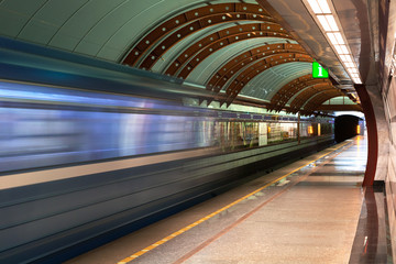 Fototapeta na wymiar Subway station. Diagonal blue motion blur metro train background. Train departure. Fast underground subway train while hurtling fast with commuters on board.