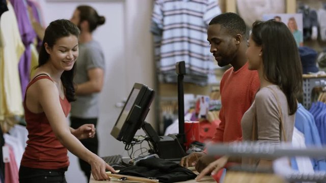  Couple in clothing store paying for a purchase with credit card