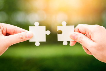 Woman hand holding jigsaw puzzle with connecting in the public park, Strategies for business...