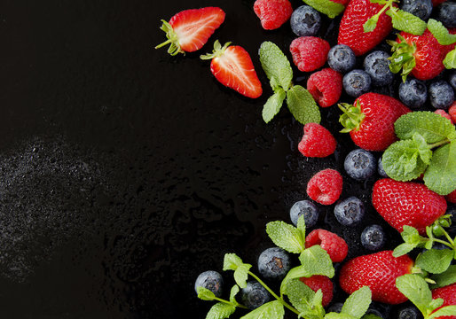 Fresh Strawberries, Raspberries And Blueberries On A Black Background