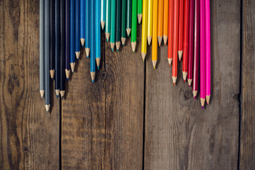 Back to school concept background with colored pencils on wooden table, flat lay