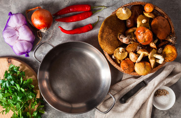 ingredients for cooking mushrooms on cutting board on grey stone background