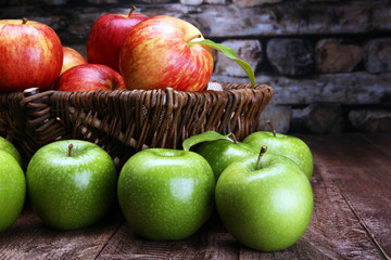 Ripe red apples and green apple on wooden background