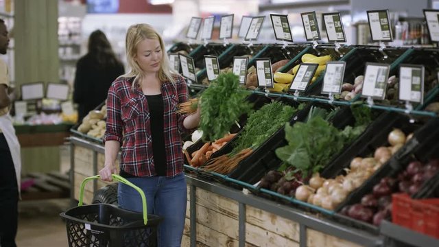  Young woman shopping for vegetables at the grocery store