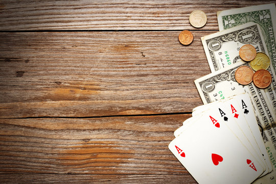 playing cards and cash on rustic wood background