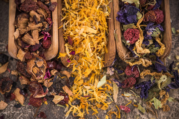 Assorted loose aromatic herbal tea on wooden spoons