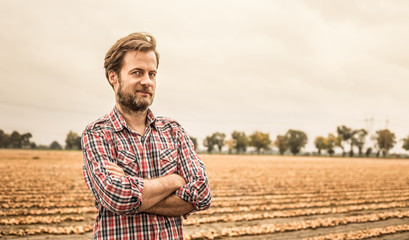 Farmer in plaid shirt and onion field - agriculture