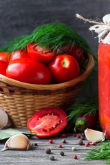 Red tomatoes and  fresh  tomato sauce with dill, garlic, pepper on a wooden table. Tomatoes conservation.