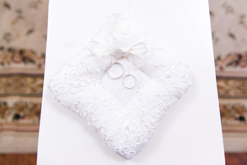 Gold wedding rings on the pillow