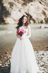 Fototapeta na wymiar Portrait of stunning bride with long hair standing by the river