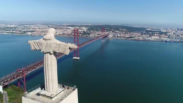 Aerial bird view of Sanctuary of Christ the King in Portuguese Santuario de Cristo Rei Catholic monument and shrine dedicated to Sacred Heart of Jesus Christ overlooking city of Lisbon Portugal 4k
