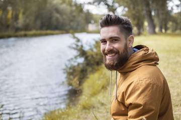 Happy man in the river of an autumnal landscape.