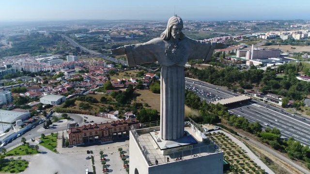 Aerial bird view panning around Sanctuary of Christ the King in Portuguese Santuario de Cristo Rei Catholic monument and shrine dedicated to Sacred Heart of Jesus Christ overlooking city of Lisbon 4k