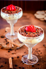 luxurious dessert Tiramisu in a glass with coffee beans and strawberries