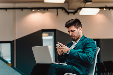 Busy bearded young man sending message on phone.