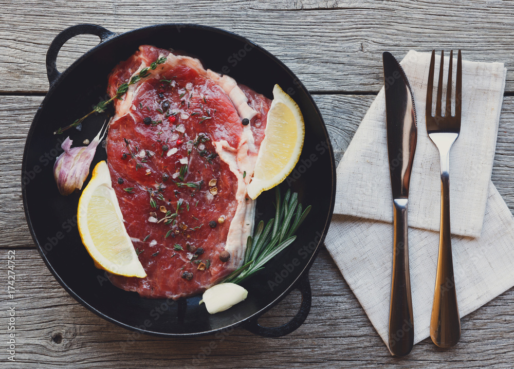 Sticker Raw beef steak on dark wooden table background, top view