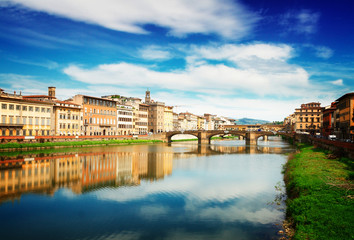 Fototapeta na wymiar old town, bridges and river Arno reflecting in water at summer day, Florence, Italy, retro toned