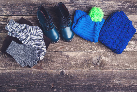 Autumn or winter outfit. Boy's fashion clothes and accessories on wooden background.