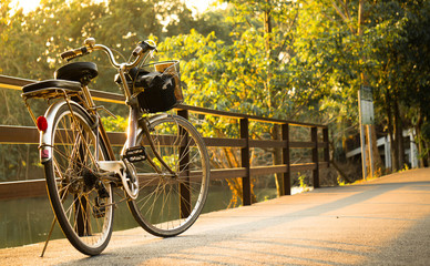 Fototapeta premium A bicycle / bike on bridge with sunlight and green tree in park outdoor for background