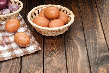 chicken eggs in basket decorated with food ingredients on wooden table