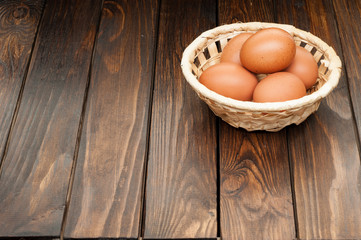chicken eggs in a basket on wooden table